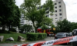 Des pompiers et policiers près d'un immeuble où s'est déclenché un incendie criminel à Décines-Charpieu, près de Lyon, le 11 mai 2026 ( AFP / JEFF PACHOUD )