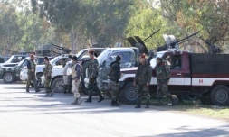 Des membres des forces gouvernementales syriennes montent la garde alors que des rebelles évacuent un quartier de Homs le 9 décembre 2015