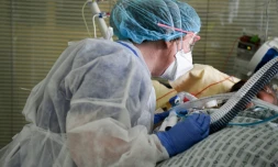 Un membre du personnel soignant et un patient atteint du Covid-19, dans l'unité de soins intensifs de l'hÎpital Ambroise-Paré, à Boulogne-Billancourt, prÚs de Paris, le 8 mars 2021