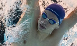 Vue prise sous l'eau du nageur français Léon Marchand lors des séries du 400 m 4 nages des JO, le 28 juillet 2024 à La Defense Arena