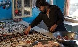 Dans cette photo prise le 14 juin 2023, Waheed, un chef cuisinier afghan propriétaire d’un restaurant à Kaboul, met de la viande dans des théières en préparant un plat traditionnel appelé « chainaki », un ragoût d’agneau