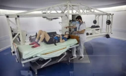 Un volontaire allongé sur une centrifugeuse est examiné par un médecin lors d'une expérience à la clinique de Medes, filiale santé du Centre national d'études spatiales (CNES), à Toulouse, le 23 mai 2023 ( AFP / Lionel BONAVENTURE )