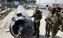 Le porte-parole de l'armée israélienne, le contre-amiral Daniel Hagari (C), et d'autres militaires se tiennent à cÎté d'un missile balistique iranien tombé en Israël, lors d'une tournée à la base de Julis dans le sud d'Israël, le 16 avril 2024 ( AFP / GIL COHEN-MAGEN )