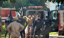 Cette photo fournie par le journal brésilien O Popular montre des gardes ramenant des prisonniers à la prison de l'Etat de Goias, le 1er janvier 2018