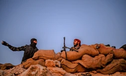 Photo prise le 19 février 2019 montrant des combattants des Forces démocratiques syriennes (FDS) sur une colline dans l'est de la Syrie, près de laquelle sont retranchés des jihadistes