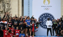 Des athlètes amateurs posent aux côtés du recordman du monde du marathon Eliud Kipchoge après avoir participé, le 31 octobre 2021 à Paris au Marathon Pour Tous, épreuve de 5 km qualificative pour les Jeux de 2024