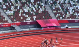 Des athlètes passent devant des tribunes vides, en raison du huis clos imposé par la pandémie, lors des séries du 1500 m aux Jeux Olympiques de Tokyo 2020, le 3 août 2021 au Stade Olympique