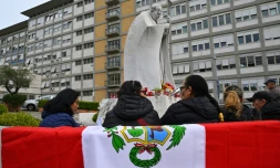 Un drapeau péruvien posé sur un banc où prient des personnes devant la statue de Jean-Paul II, à l'extérieur de l'hôpital Gemelli à Rome, où le pape François est soigné pour une pneumonie
