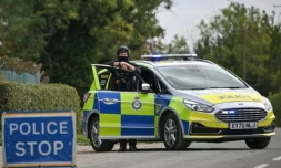 Un policier sur un barrage établi près de la base aérienne de Fairford, dans le sud-ouest de l'Angleterre, le 27 septembre 2026 ( AFP / JUSTIN TALLIS )