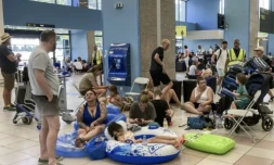 Des touristes attendent leur évacuation dans le hall des départs de l'aéroport international de Rhodes, en Grèce, le 23 juillet 2023 ( AFP / Will VASSILOPOULOS )