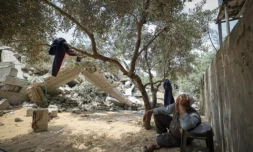 Photo prise le 15 mai 2023 montrant un membre de la famille palestinienne Nabhane assis près des décombres de sa maison, détruite par une frappe israélienne à Beit Lahya dans le nord de la bande de Gaza ( AFP / MAHMUD HAMS )