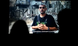 Le photographe palestinien Mahmoud Abu Hamda prononce un discours préenregistré, diffusé sur écran, après avoir reçu le prix du jury international de l'édition 2026 du Prix Bayeux Calvados-Normandie des correspondants de guerre, à Bayeux, le 10 octobre 2026