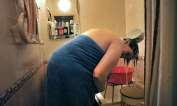 Une femme se lave les cheveux avec de l'eau qu'elle a chauffée le 7 juillet 2016 à Saint-Pétersbourg à cause des coupures traditionnelles d'eau chaude en été