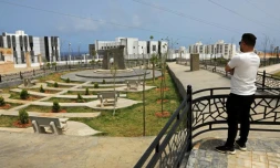 Un homme observe le nouveau projet de logements en construction dans le quartier d'Al-Salam à Derna, le 17 mai 2026, dans le cadre du plan de reconstruction de la ville, près de trois ans après le passage dévastateur d'une tempête qui a fait près de 4 000 victimes