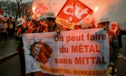 Des employés d'ArcelorMittal, venus en bus de leurs sites du Nord et de la Moselle, défilent lors d'une action organisée par la CGT sur l'Esplanade des Invalides, en soutien au projet de loi LFI, examiné par les députés, le 27 novembre 2025 à Paris ( AFP / Alain JOCARD )