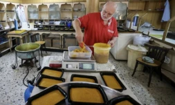 Hassan al-Makari pèse la mfatka dans son échoppe à Beyrouth, le 29 août 2024 au Liban ( AFP / ANWAR AMRO )