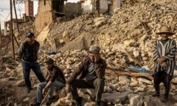 Des personnes sont assises au milieu des décombres dans le village de Douzrou, dans le centre du Maroc, le 13 février 2024. Cette région a été frappée par un sésime le 8 septembre 2023 ( AFP / FADEL SENNA )