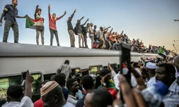 Des manifestants venus de la ville d'Atbara (centre du Soudan) font le signe de la victoire en arrivant en train Ă Khartoum le 23 avril 2019