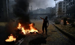 Un manifestant se tient debout prÚs d'un feu de paille et de pneus à Bruxelles le 26 février 2024 ( )