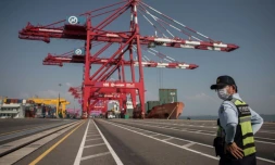Un agent de sureté surveille le chargement de porte-conteneurs amarrés le long des quais du terminal portuaire de Séoul, le 3 septembre 2016