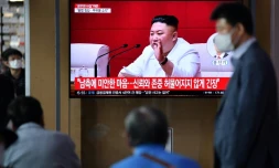 Des Sud-Coréens regardent des images du leader nord-coréen Kim Jong Un sur un écran de télévision dans une gare de Séoul, le 25 septembre 2020