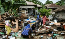 Des habitants récupèrent des affaires personnels dans les décombres de leurs maisons, le 25 décembre 2018 à Rajabasa, trois jours après le tsunami qui a frappé l'Indonésie