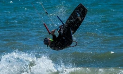 Un surfeur avec son masque profite des joies de la mer à Ladispoli (40 kms de Rome), le 7 mai 2020