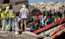 Des membres des forces de police et des services d'urgence aident des migrants à leur arrivée au port de Restinga sur l'île d'El Hierro, le 18 août 2024 aux Canaries