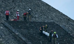 Des experts médico-légaux et des membres de la Croix-Rouge transportent un corps sur la pyramide de la Lune, sur le site archéologique de Teotihuacan, après une fusillade survenue à Teotihuacan, dans l'Etat de Mexico, le 20 avril 2026
