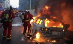 Des pompiers tentent d'éteindre une voiture en feu en marge d'une manifestation à Nanterre, théùtre d'incidents en soirée, le 27 juin 2023 ( AFP / Zakaria ABDELKAFI )