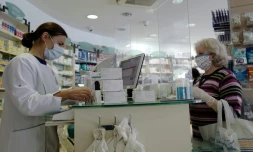 Une pharmacienne sert un client derriĂšre un plexiglas protecteur (Hygiaphone) Ă Nice, le 2 mai 2020