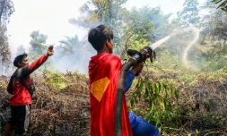 'adolescent indonésien Rudiansyah porte un costume de "Superman" en combattant un incendie, à Palangkaraya, dans le Kalimantan central, le 17 août 2026