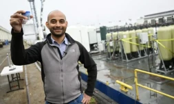 Gaurav Sant, directeur de l'Institut de gestion du carbone de l'université UCLA, montre la poudre blanche dans laquelle est piégéé le CO2 contenu dans l'eau de mer, grùce au projet SeaChange installé sur une barge, le 12 avril 2023 au port de Los Angeles ( AFP / Patrick T. Fallon )