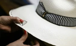 Une artisane coud le rebord d'un chapeau Borsalino, dans sa manufacture à Alexandrie dans le nord de l'Italie, le 28 mars 2023 ( AFP / GABRIEL BOUYS )