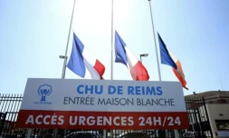 Drapeaux tricolores en berne à l'entrée de l'hôpital de Reims où a été mortellement blessée une infirmière, le 24 mai 2023 ( AFP / FRANCOIS NASCIMBENI )