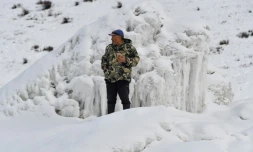 Le fermier Erkinbek Kaldanov sur un glacier artificiel près du village de Syn-Tash au Kirghizstan, le 13 février 2024
