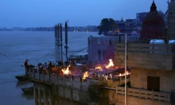 Des fidèles hindous se tiennent près des bûchers funéraires à Varanasi, le long des rives du Gange en Inde, le 31 août 2024 ( AFP / Niharika KULKARNI )