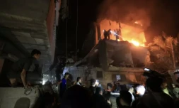 Des personnes utilisent les lampes de leurs téléphones mobiles pour chercher des victimes dans les décombres d'un immeuble touché par une frappe israélienne, le 6 décembre 2023 à Rafah, dans la bande de Gaza ( AFP / MAHMUD HAMS )