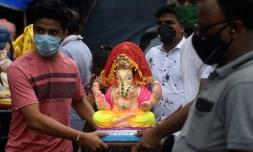 Des fidèles transportent une effigie du dieu hindou à tête d'éléphant au premier jour de la fête de Ganesh à Bombay le 22 aout 2020