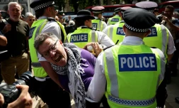 Un manifestant est emmené par des policiers lors d'une manifestation « Lift The Ban » (Lève l'interdiction) en soutien au groupe interdit Palestine Action, qui réclame la levée de l'interdiction récemment imposée, sur Parliament Square, dans le centre de Londres, le 9 août 2025