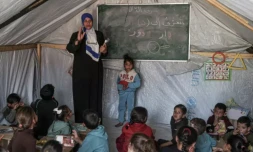 Une enseignante fait un cours à ses élèves le 27 mars 2024 dans une tente d'un camp de déplacés palestiniens à Rafah, dans le sud de la bande de Gaza, où une guerre oppose Israël au mouvement islamiste Hamas ( AFP / SAID KHATIB )