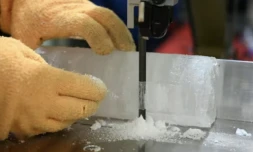 Le professeur Yoshinori Iizuka coupe une tranche d'un échantillon de carotte de glace, à l'Institut des sciences cryogéniques de l'université d'Hokkaido, à Sapporo, au Japon, le 9 décembre 2025 ( AFP / GREG BAKER )