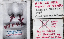Affichettes sur la devanture d'un commerce à Paris demandant le port du masque, le 27 juin 2021