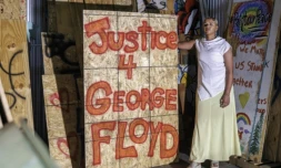 Kenda Zellner-Smith pose dans un container de stockage avec un des panneaux de bois qu'elle a collectés en 2020 après la mort de George Floyd, le 25 mai 2025 à Minneapolis, dans le Minnesota ( AFP / Kerem YUCEL )