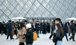 Des visiteurs devant la pyramide du Louvre le 15 décembre 2025 à Paris