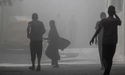 Des Palestiniens marchent dans la fumée et la poussière au camp de Nousseirat, dans le centre de la bande de Gaza, le 8 juin 2024