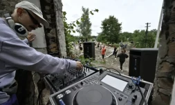 Un DJ joue de la musique électro pour les bénévoles de "Réparer ensemble", dans le village de Iaguidné, dans le nord de l'Ukraine, le 8 juillet 2023 ( AFP / Genya SAVILOV )