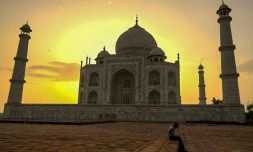 Un gardien du Taj Mahal se repose au lever du soleil le 16 juin 2021, jour de la réouverture de ce monument à Agra en Inde