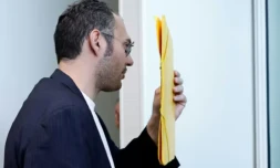 David G., animateur pĂ©riscolaire, se cache le visage avec un dossier Ă son arrivĂ©e au tribunal oĂč il doit ĂȘtre jugĂ© pour agressions sexuelles sur neuf enfants, le 26 mai 2026 Ă Paris ( AFP / SIMON WOHLFAHRT )