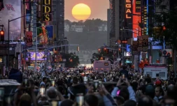 Le soleil aligné entre les rangées de gratte-ciel qui quadrillent l'île de Manhattan, à New York, le 30 mai 2023. Le phénomène qui a lieu quatre fois par an est connu sous le nom de "Manhattanhenge" et fait descendre des centaines de New-Yorkais dans les rues ( AFP / Ed JONES )